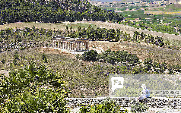 Visitor admiring view over the magnificent Doric temple at the ancient Greek city of Segesta  Calatafimi  Trapani  Sicily  Italy  Mediterranean  Europe