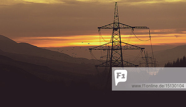 Markante Pylone verlaufen durch einen dunstigen Sonnenuntergang im Peak District  South Yorkshire  Yorkshire  England  Vereinigtes Königreich  Europa