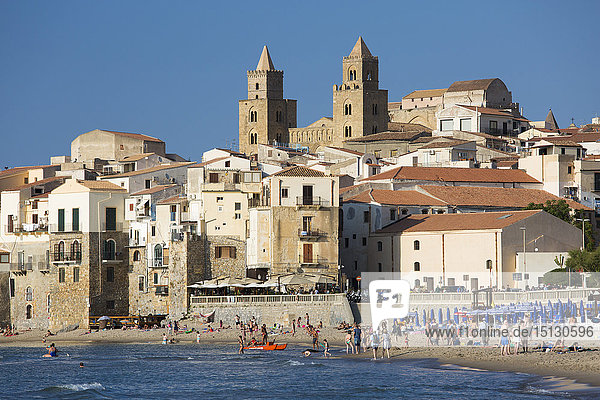 Blick vom Strand entlang der Wasserkante auf die Stadt und die zum UNESCO-Weltkulturerbe gehörende arabisch-normannische Kathedrale  Cefalu  Palermo  Sizilien  Italien  Mittelmeer  Europa