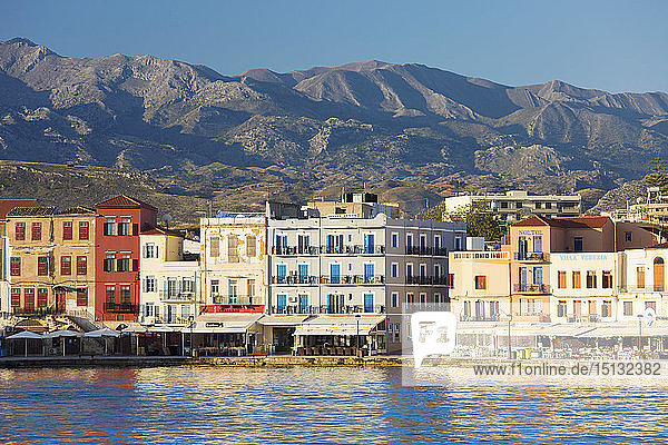 View across the Venetian Harbour to colourful waterfront buildings beneath the Lefka Ori  Hania (Chania)  Crete  Greek Islands  Greece  Europe