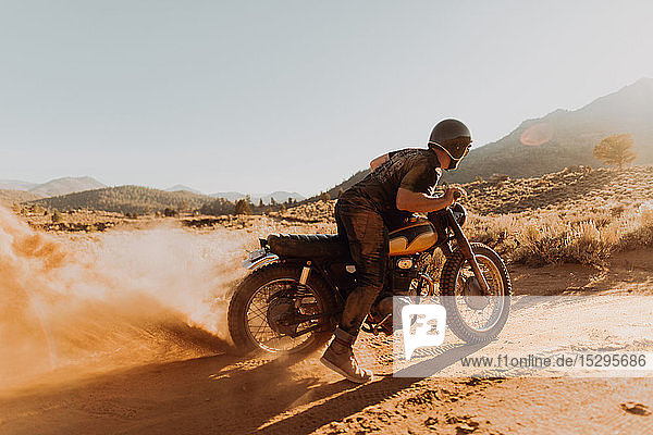 Motorbiker raising dust  Kennedy Meadows  California  US