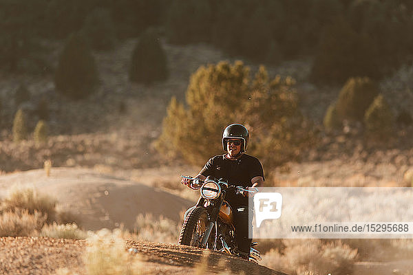 Motorbiker riding through landscape of Kennedy Meadows  California  US