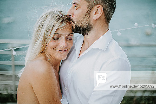 Romantischer mittelgroßer Mann küsst am Seeufer die Stirn seiner Freundin  Stresa  Piemont  Italien