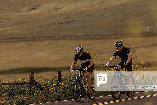 Junges Radfahrerpaar radelt auf einer Landstraße,  Exeter,  Kalifornien,  USA