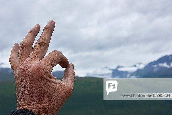 Mann macht OK-Zeichen in Berglandschaft  Nahaufnahme  Valdez  Alaska  USA