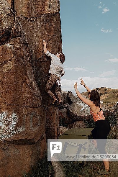 Junger Mann klettert eine Felswand hoch  Freundin schaut zu  Exeter  Kalifornien  USA