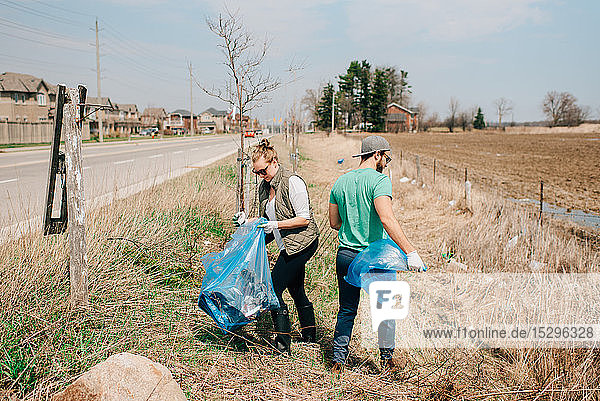 Ehepaar beim Aufsammeln von Müll am Straßenrand  Georgetown  Kanada