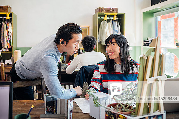 Junge Geschäftsfrau und Mann unterhalten sich am Café-Tisch