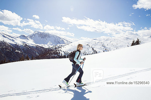 Schneeschuhwanderung einer erwachsenen Frau auf schneebedeckten Berghängen  Steiermark  Tirol  Österreich
