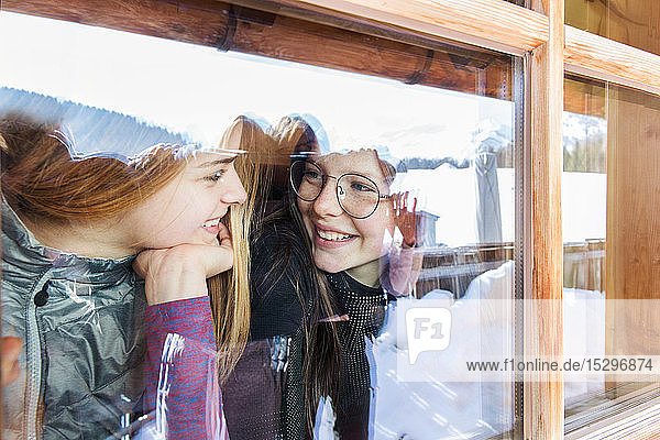 Zwei jugendliche Skifahrerinnen unterhalten sich am Kabinenfenster  Tirol  Steiermark  Österreich