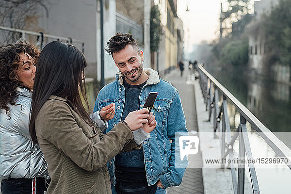 Freunde mit Smartphone am Fluss  Mailand  Lombardei  Italien