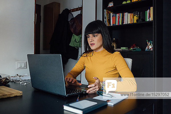 Frau benutzt Laptop im Heimbüro