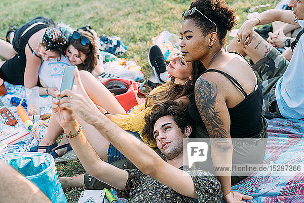 Eine Gruppe von Freunden entspannt sich  macht ein Picknick im Park