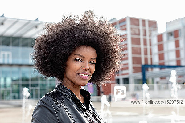 Junge Frau mit Afro-Haaren in der Stadthalle  Porträt
