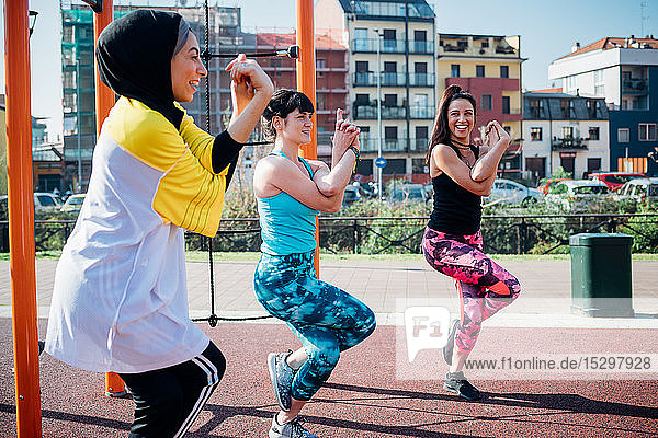Calisthenics-Kurs im Fitnessstudio im Freien  junge Frauen balancieren auf einem Bein  Seitenansicht