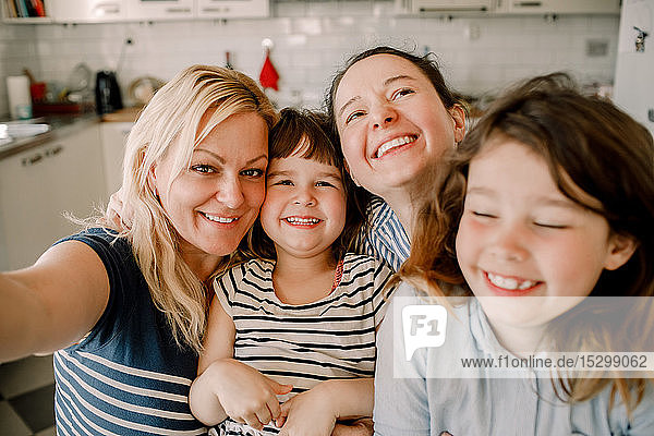 Portrait of smiling mother and daughters at home