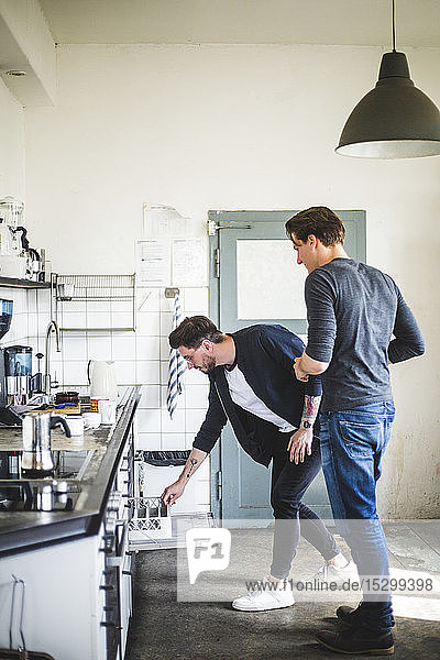Männliche Programmierer in voller Länge in der Küche des Kreativbüros