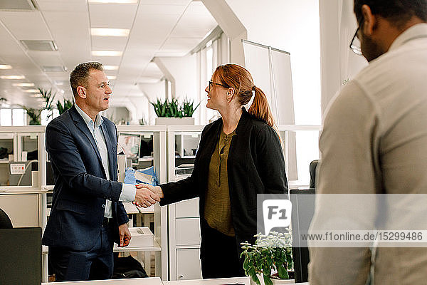 Geschäftsfrau schüttelt Hand mit Verkaufsleiter im Büro