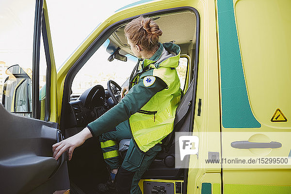 Female paramedic closing door of ambulance