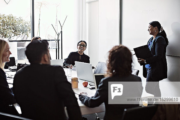 Lächelnde Geschäftsleute während einer Besprechung im Büro