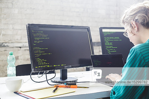 Seitenansicht einer Geschäftsfrau  die während der Kodierung im Büro an einem Start-up-Projekt arbeitet