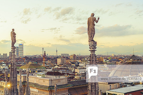 View of the statues on spires of Milan Cathedral at sunset Italy