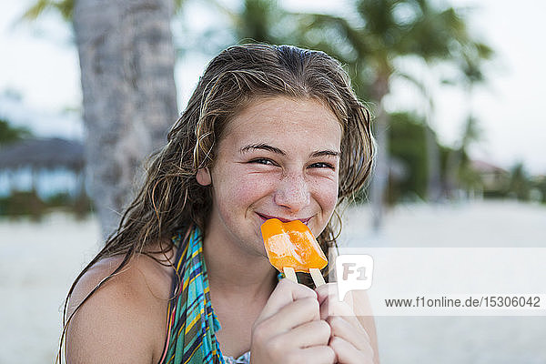 Ein junges Mädchen isst im Urlaub ein Eis am Stiel