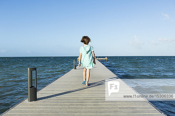 5 year old boy walking on a pier  view to the horizon