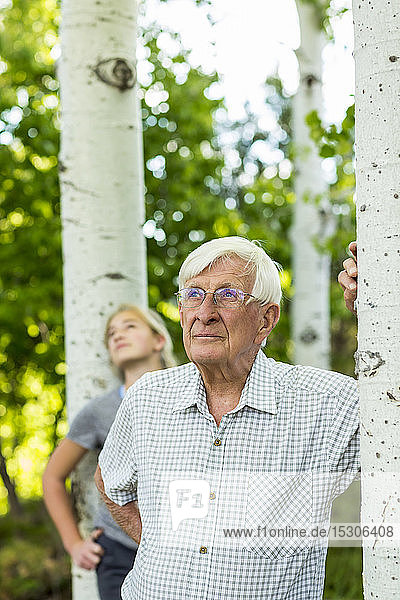 Senior-Großvater mit seiner jugendlichen Enkelin im Espenwald