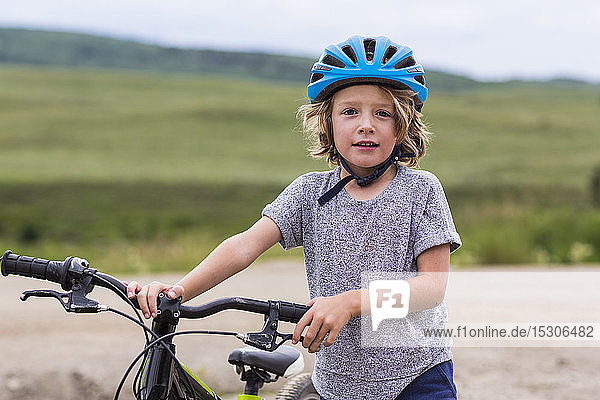 portrait of 5 year old boy holding his mountain bike