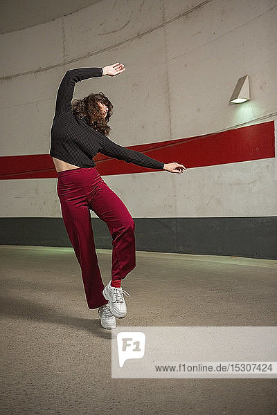 Unbekümmerte junge Frau tanzt im Tunnel