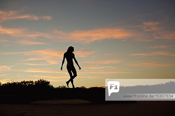 Silhouette woman on beach at dusk