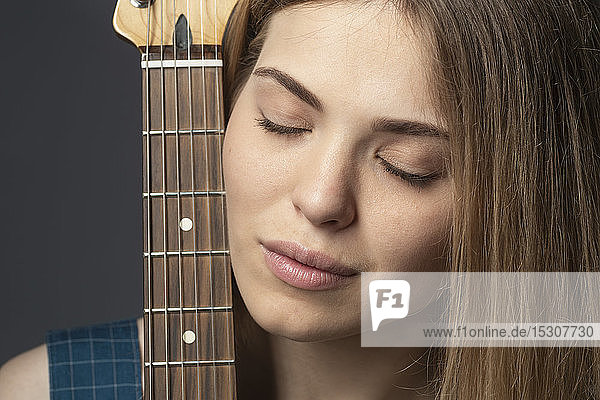 Nahaufnahme Porträt heitere junge Frau mit Gitarre