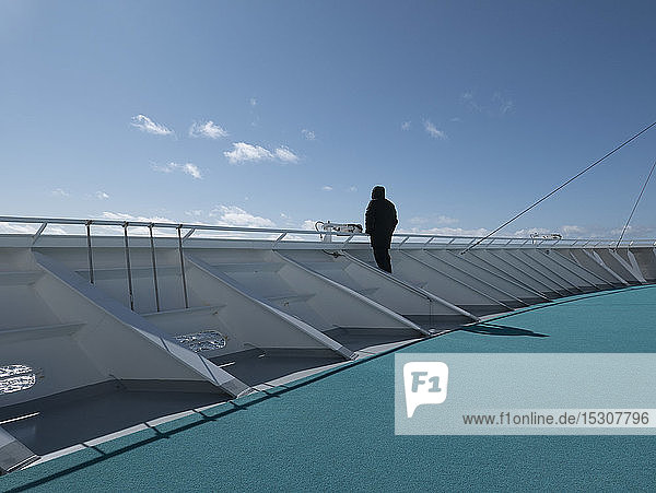 Tourist auf dem sonnigen Deck eines Kreuzfahrtschiffs