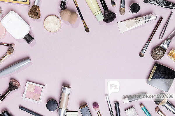 Blick von oben Make-up und Beauty-Produkte auf rosa Hintergrund - knolling