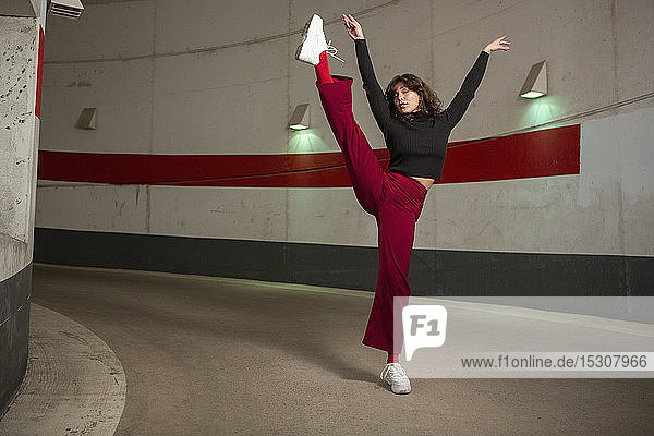 Portrait confident young woman dancing in tunnel