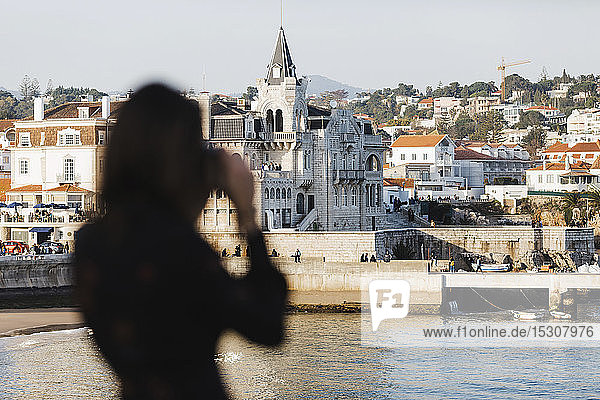 Silhouette einer Touristin beim Fotografieren von Architektur  Cascais  Lissabon  Portugal