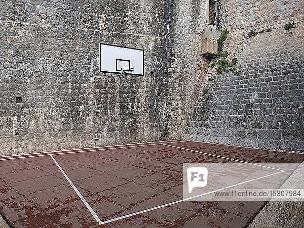 Basketballplatz und Basketballkorb im steinernen Innenhof