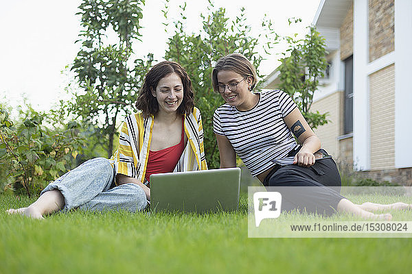 Freundinnen benutzen Laptop im Gras
