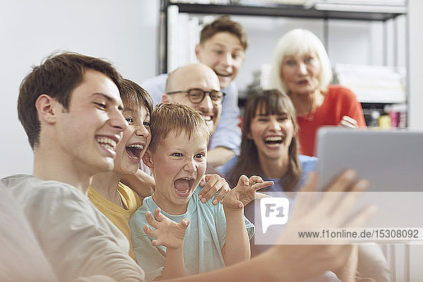 Große Familie hat Spaß zu Hause und verwendet ein digitales Tablet