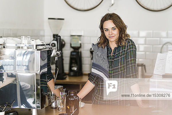 Stolze junge Frau  die in ihrem eigenen Café arbeitet