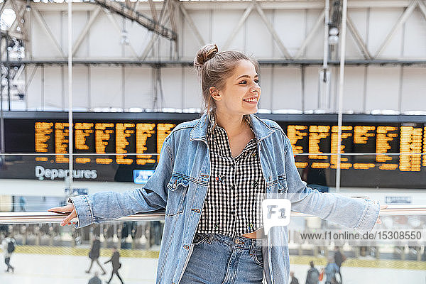 Porträt einer glücklichen jungen Frau am Bahnhof  London  UK
