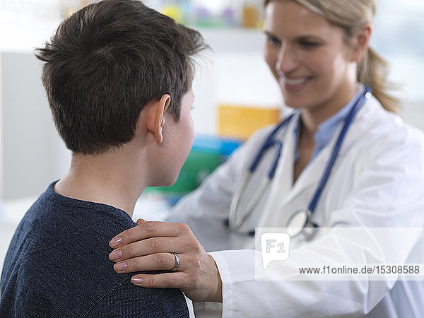 Ärztin  die einem Jungen bei einem Termin in der Klinik eine Anleitung gibt