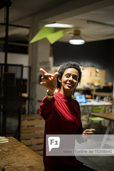 Businesswoman throwing a paper plane in office