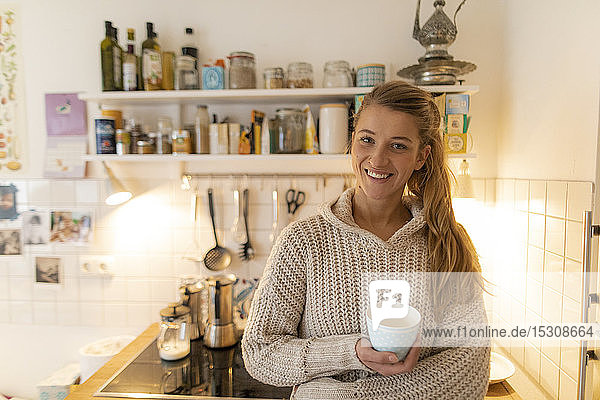 Portrait of smiling young woman in kitchen at home