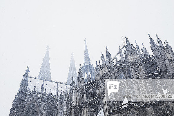 Niedrigwinkelansicht des Kölner Doms bei Schneefall gegen den Himmel