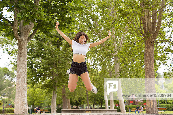 Young woman jumping in park