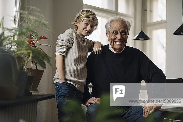 Portrait of happy grandfather and grandson at home