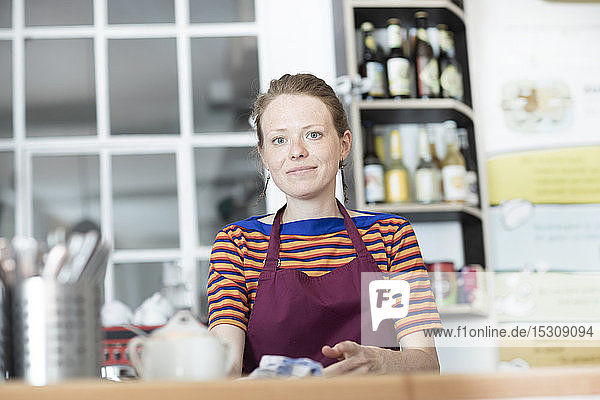 Porträt einer Frau mit Schürze in einem Cafe