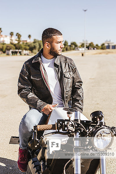 Portrait of bearded young man sitting on his motorbike